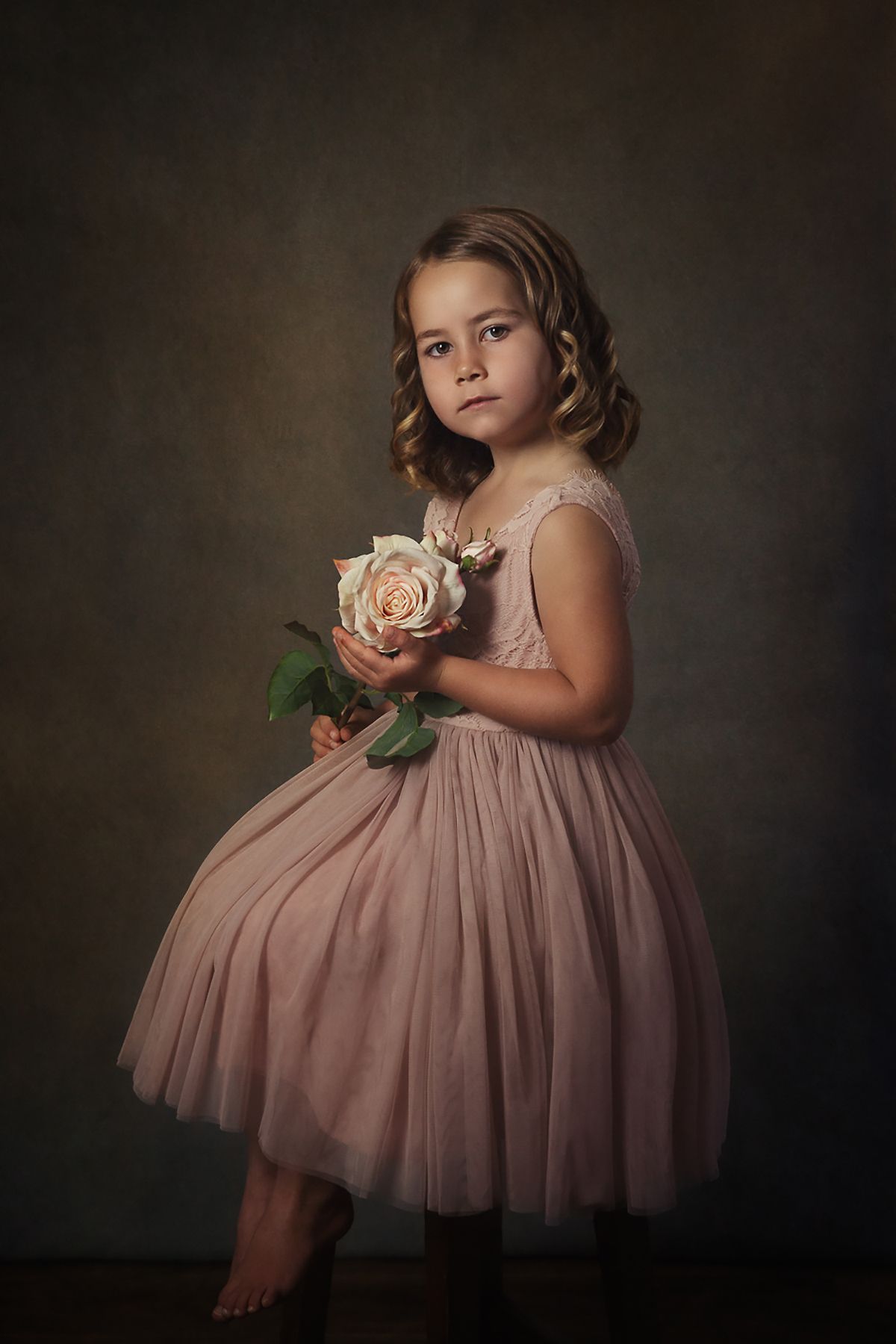 Dreamy portrait featuring a dusty pink tulle dress and a white rose.