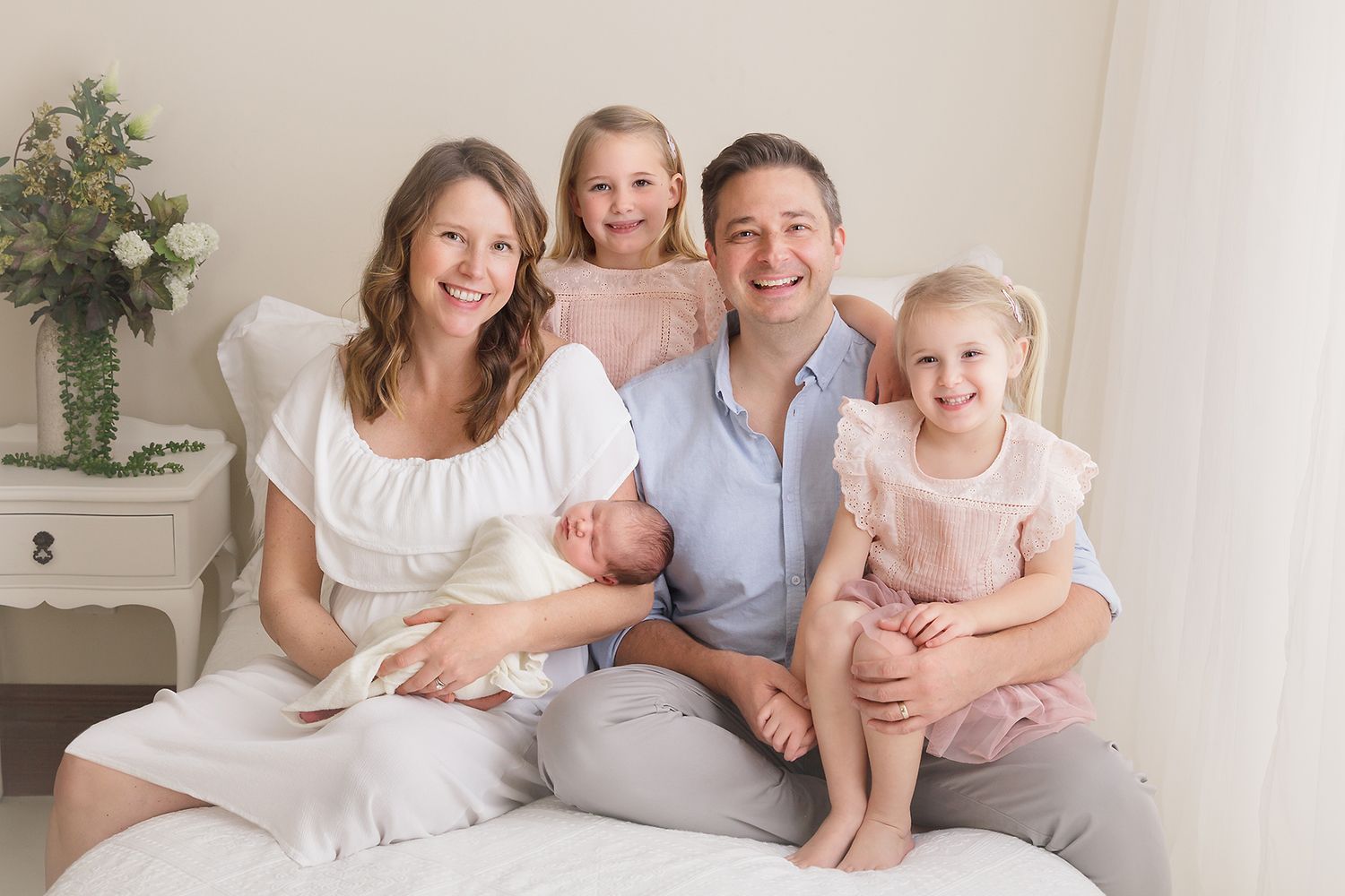 Bright and airy family portrait session in an all-white studio setting.