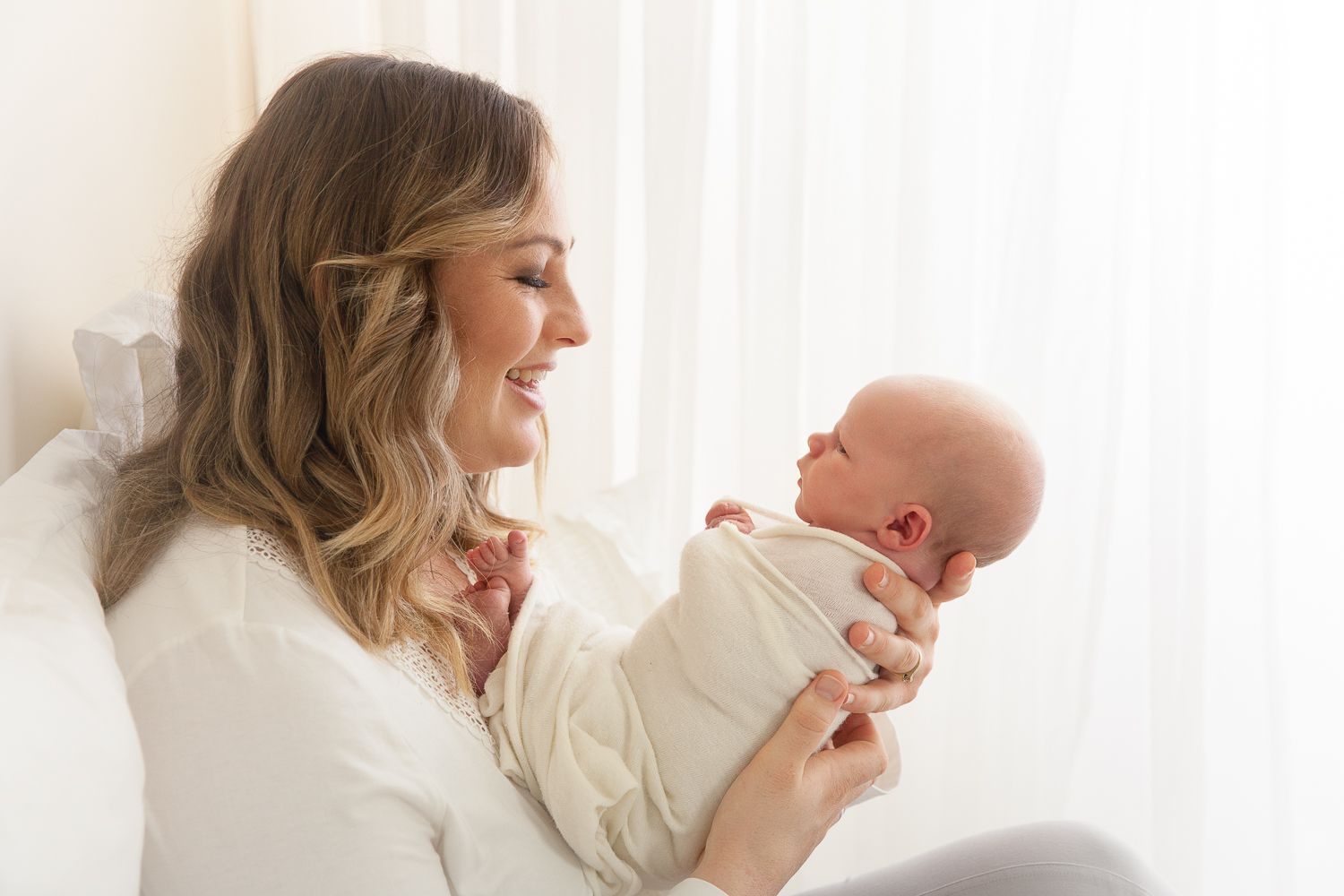 Tender family moment captured in bright white studio setting.