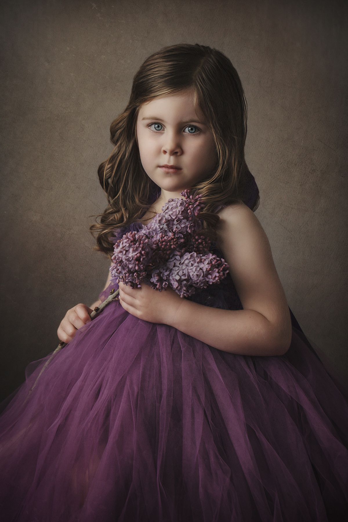 Dramatic portrait featuring a flowing purple tulle dress adorned with lilac flowers.