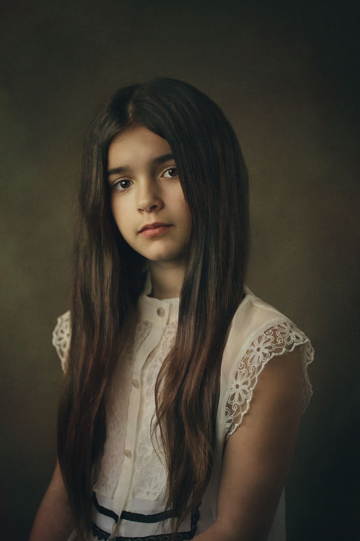 Moody portrait featuring a white lace blouse with black ribbon detail against dark background.