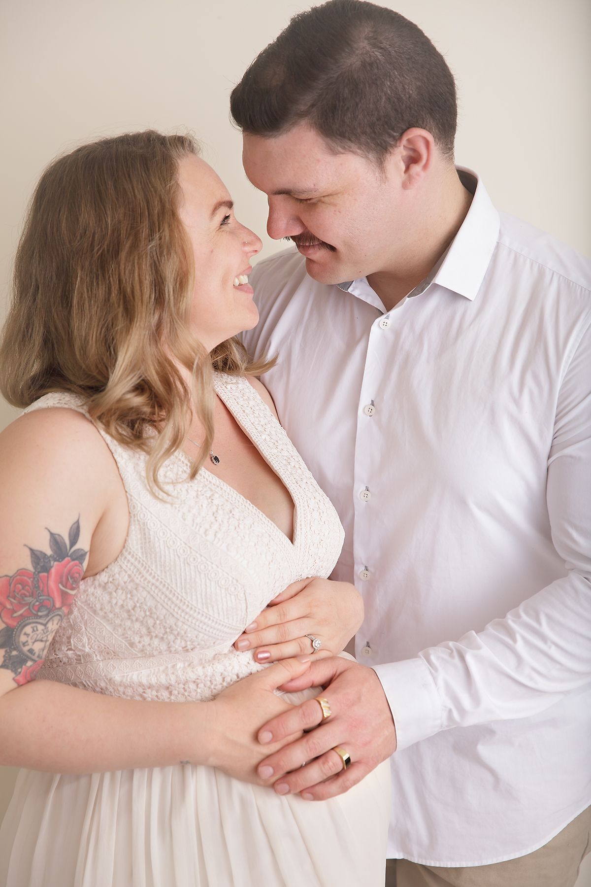 Intimate couple's portrait session showing tender moments against a neutral backdrop.