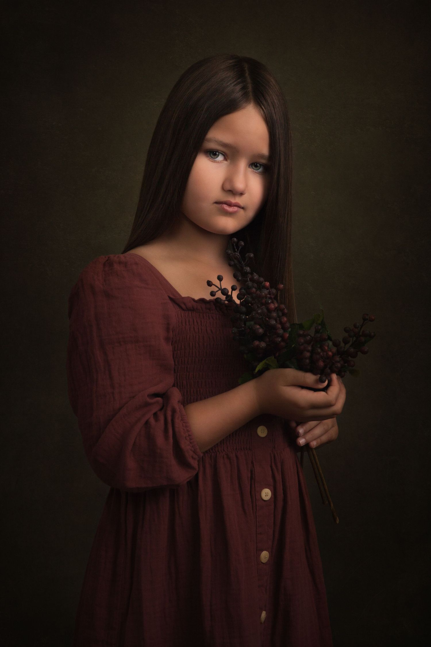 A moody portrait featuring a burgundy dress and dark purple florals against a shadowy background.