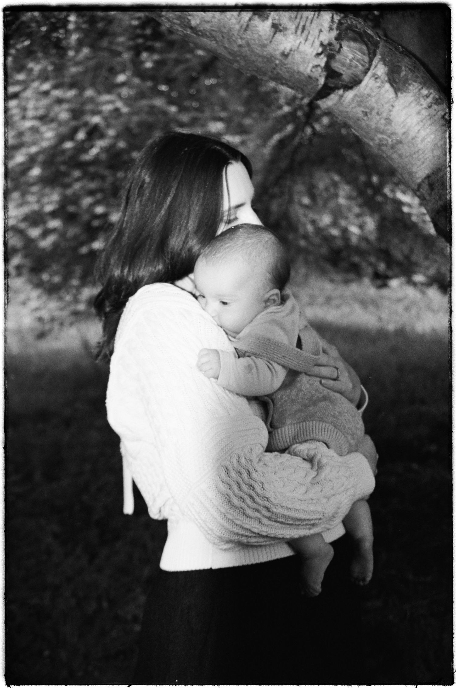 Black and white photos show tender moments between a parent and young child embracing outdoors.