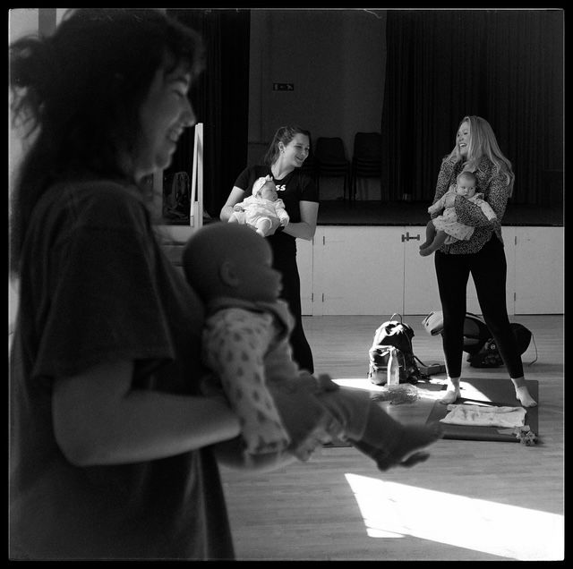 People practicing ballet moves at a dance studio, captured in dramatic black and white lighting through multiple photos.