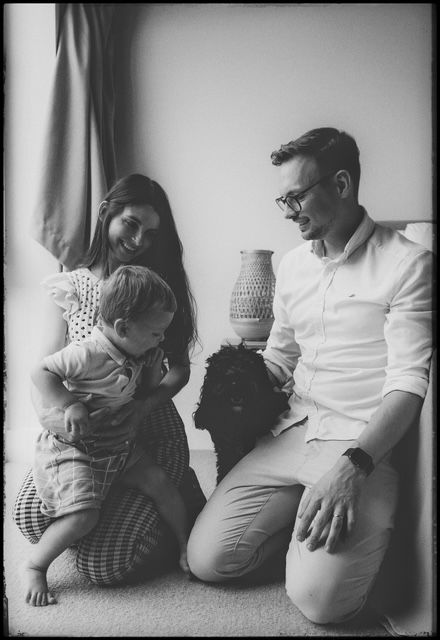 A black and white photo sequence showing moments of closeness and interaction between parent and child against a plain wall.