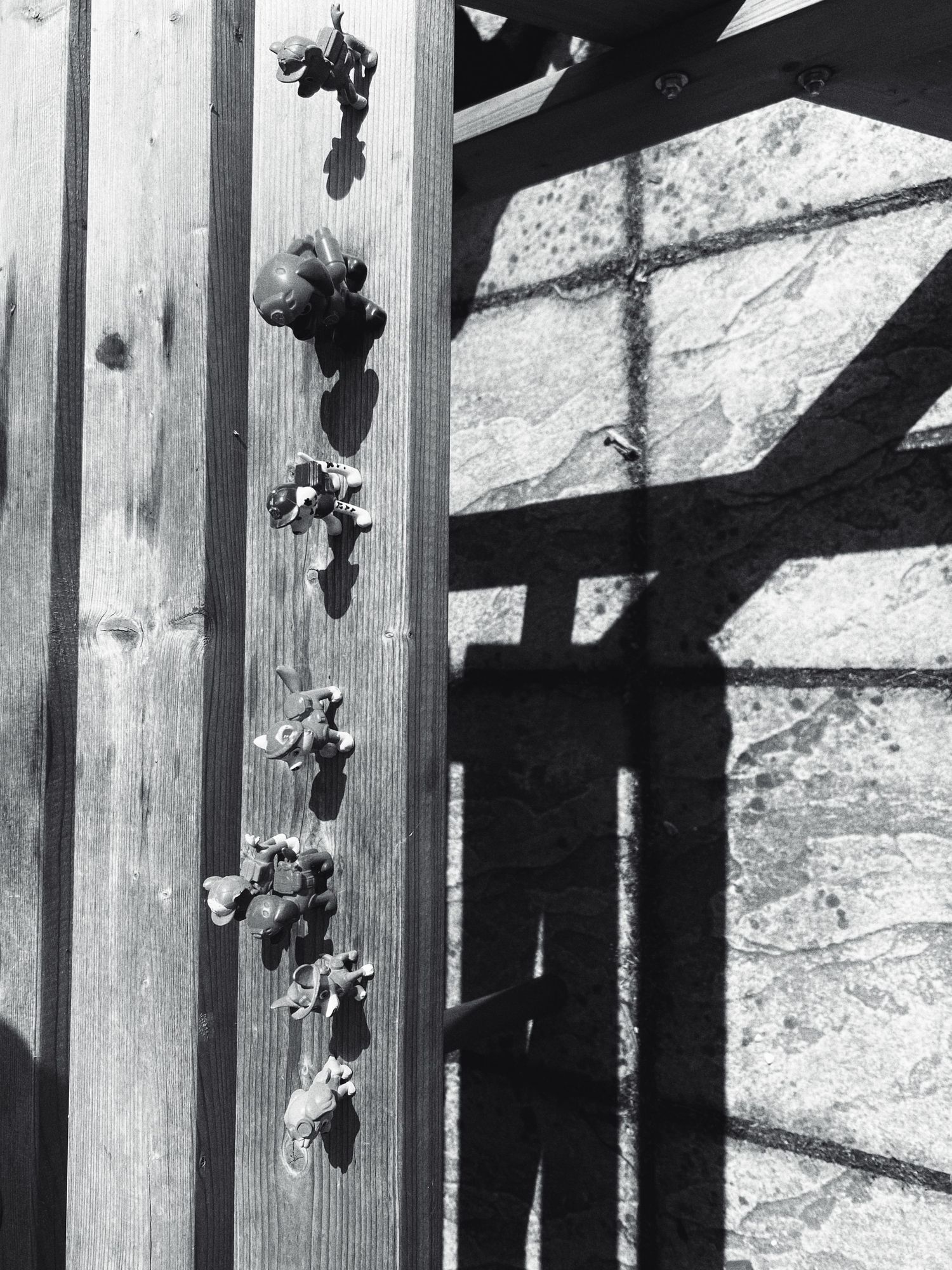 Architectural detail showing wooden beams casting geometric shadows on a stone wall.