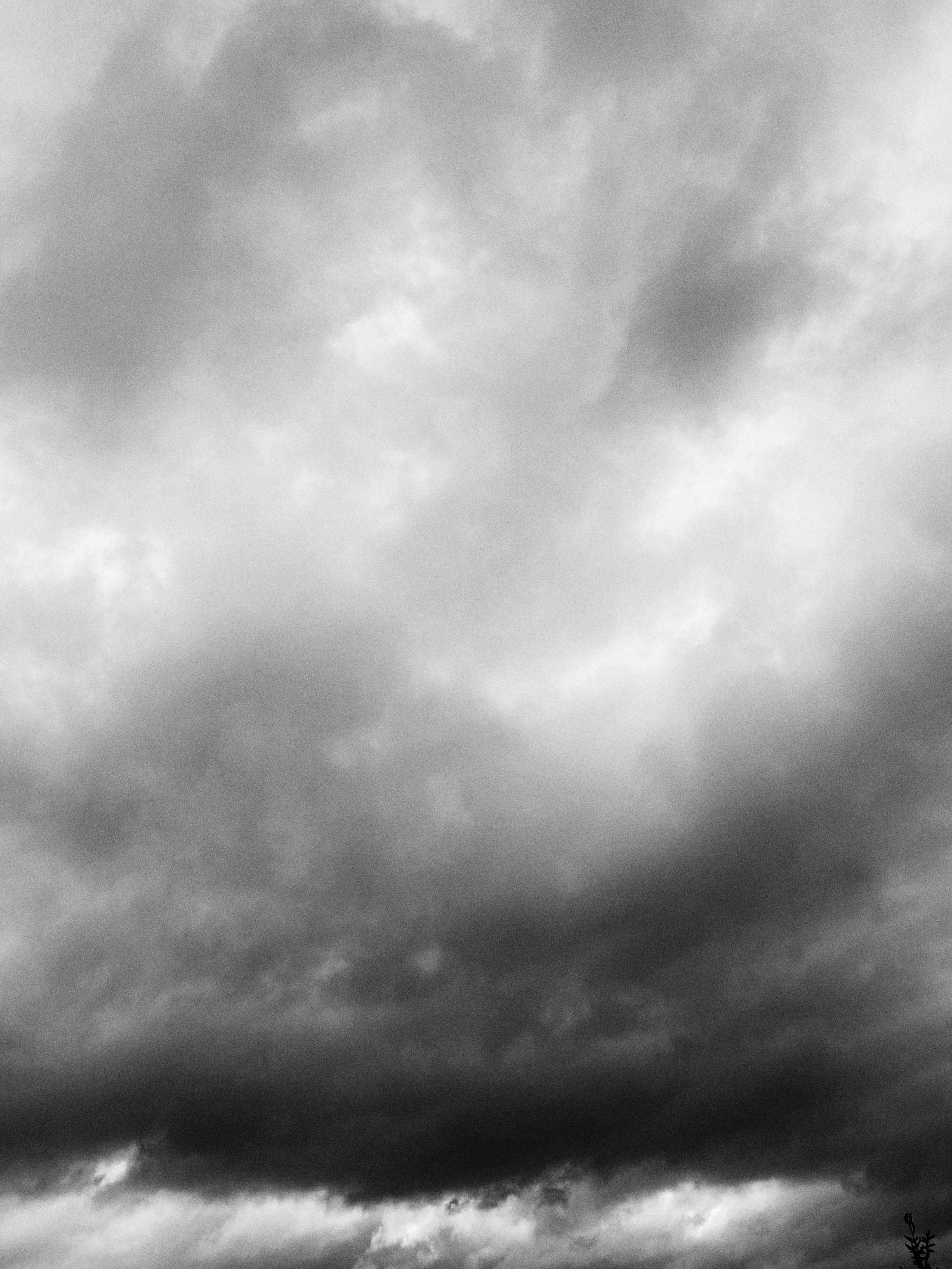 Dark storm clouds gather in a dramatic black and white sky creating an ominous atmosphere.