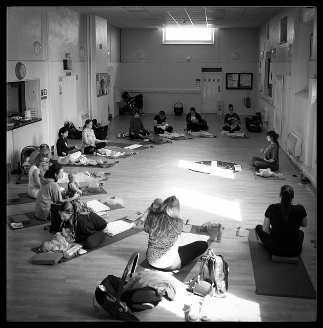 Students sit on the floor in a classroom or studio space during what appears to be a group study or workshop session.
