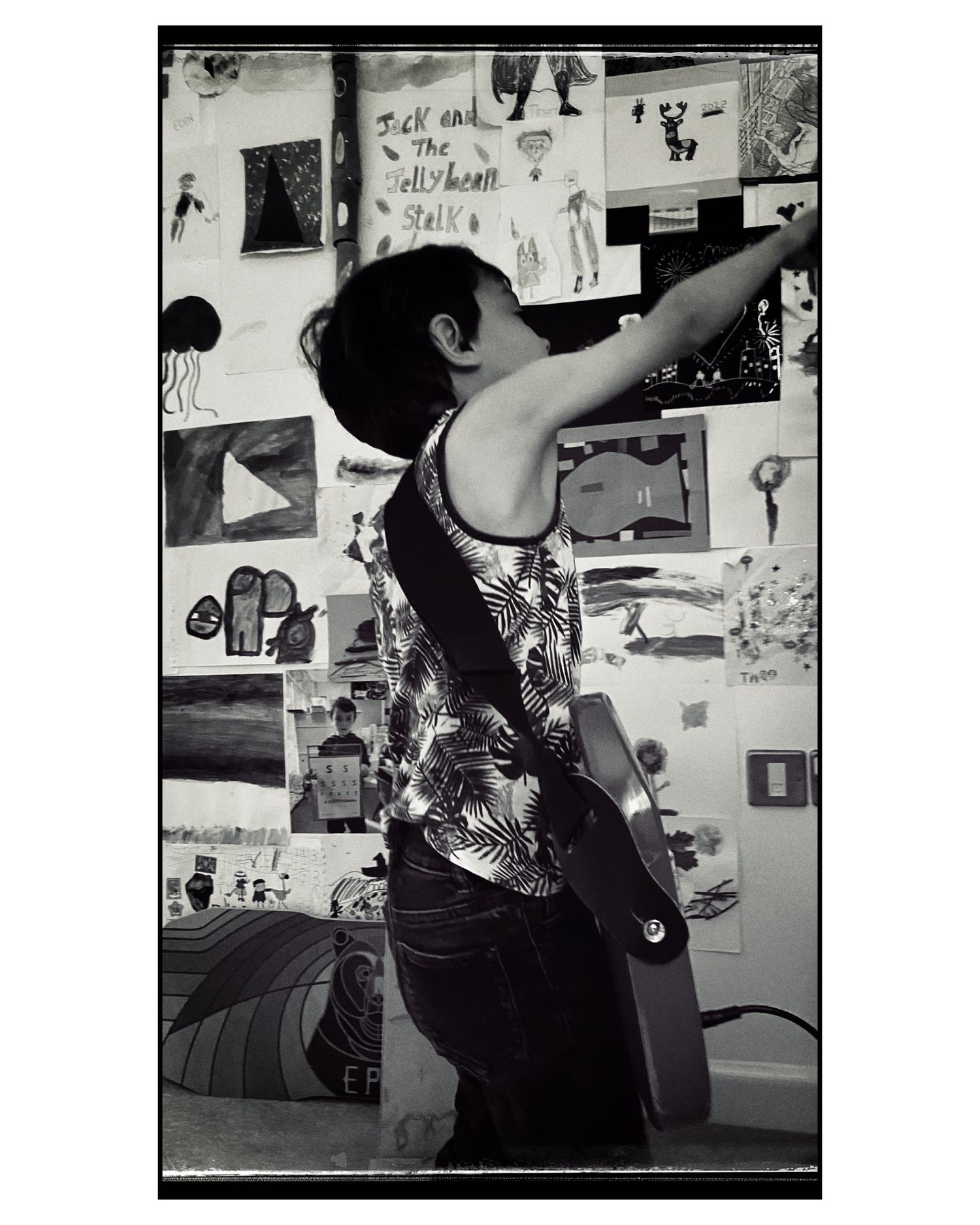 Dancer stretching in a room covered with artistic posters and drawings.