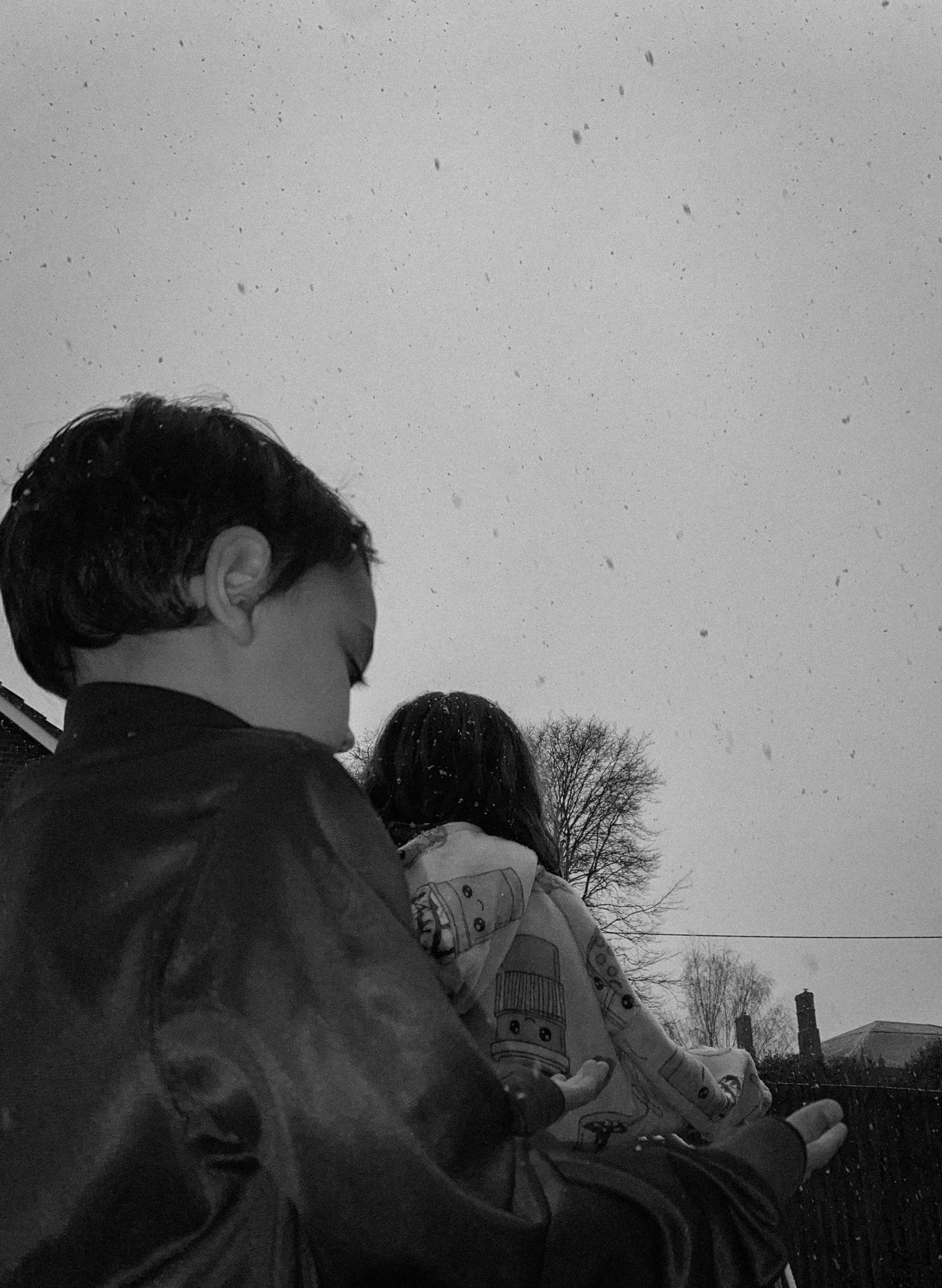Black and white outdoor scene with figures viewing something in the distance.