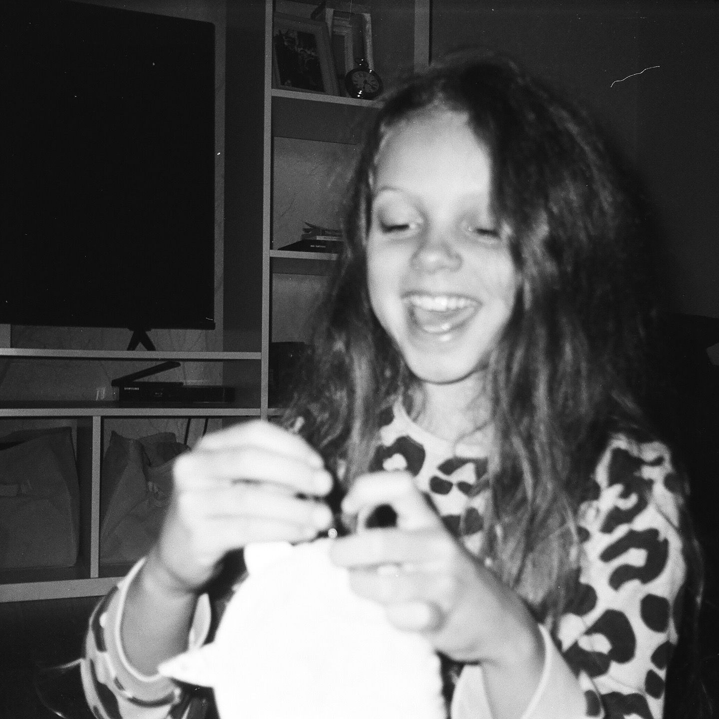 Person joyfully crafting with materials in a cozy indoor setting.