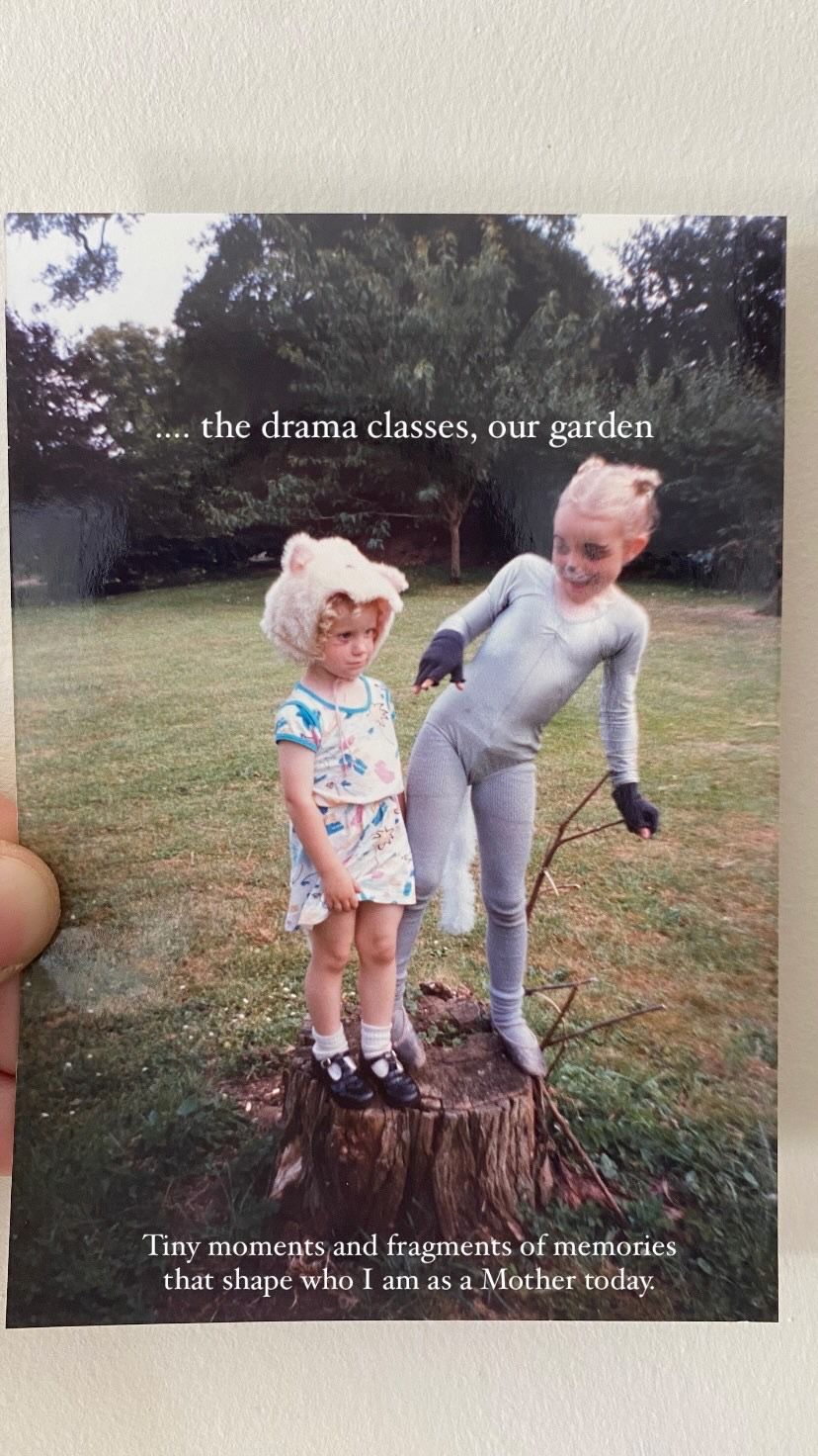 Two people stand in a garden near a tree stump during what appears to be a drama class activity.