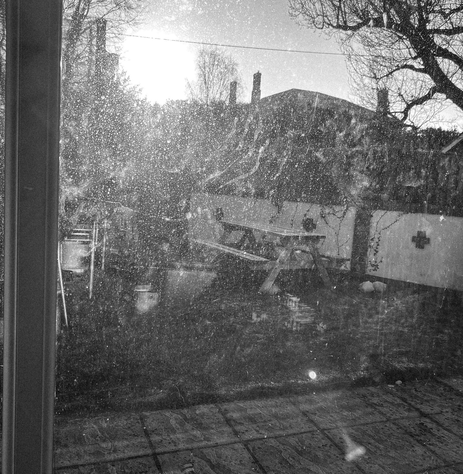Snowy winter landscape view through a window with buildings in the distance.