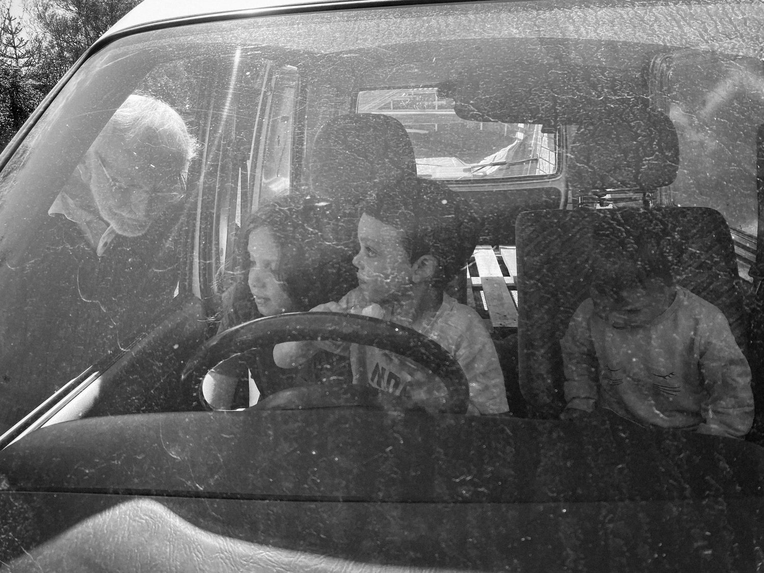 View through a car windshield showing passengers inside during a drive.