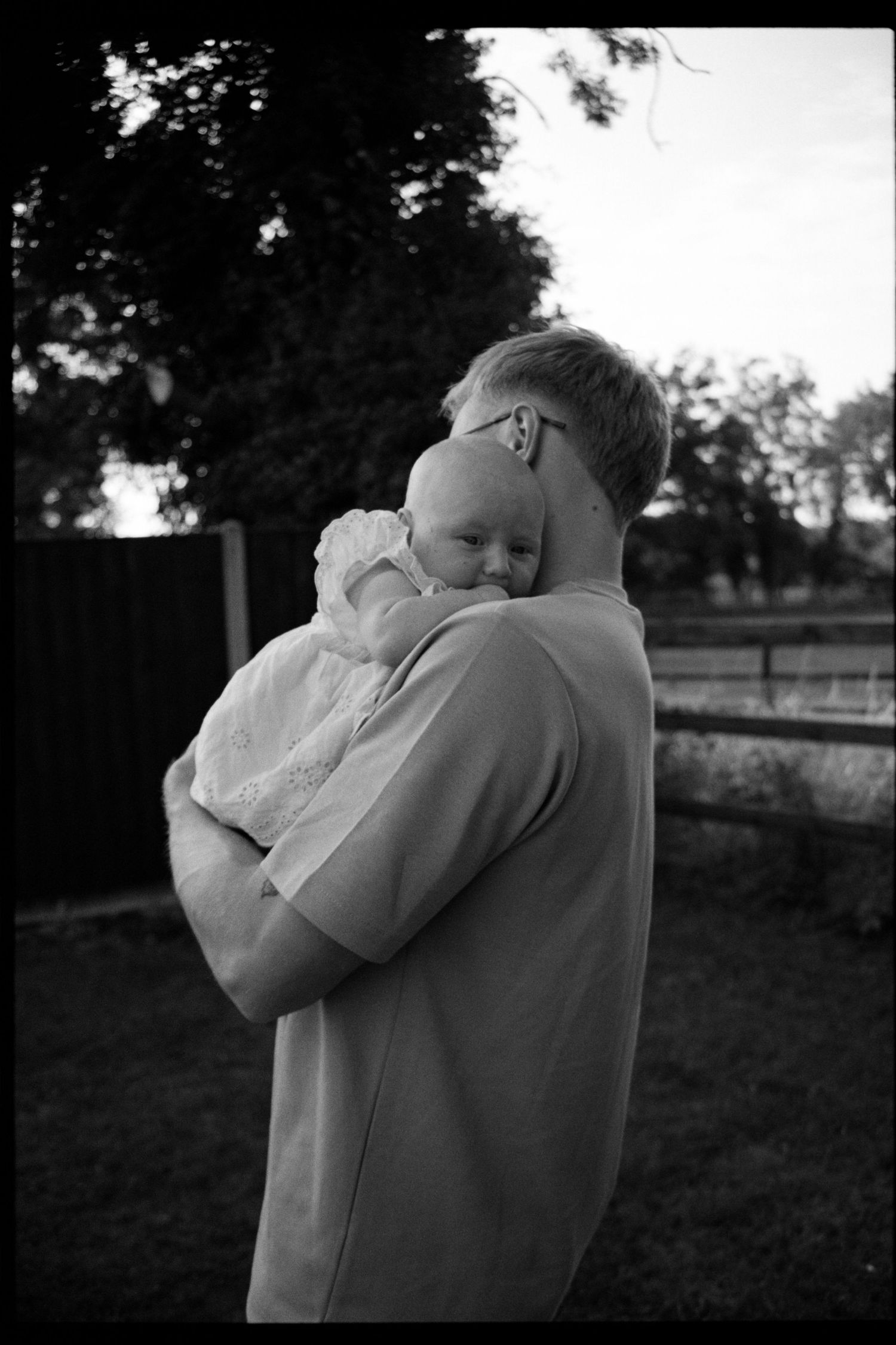Black and white photo sequence showing a tender embrace between two people in an outdoor setting at dusk.