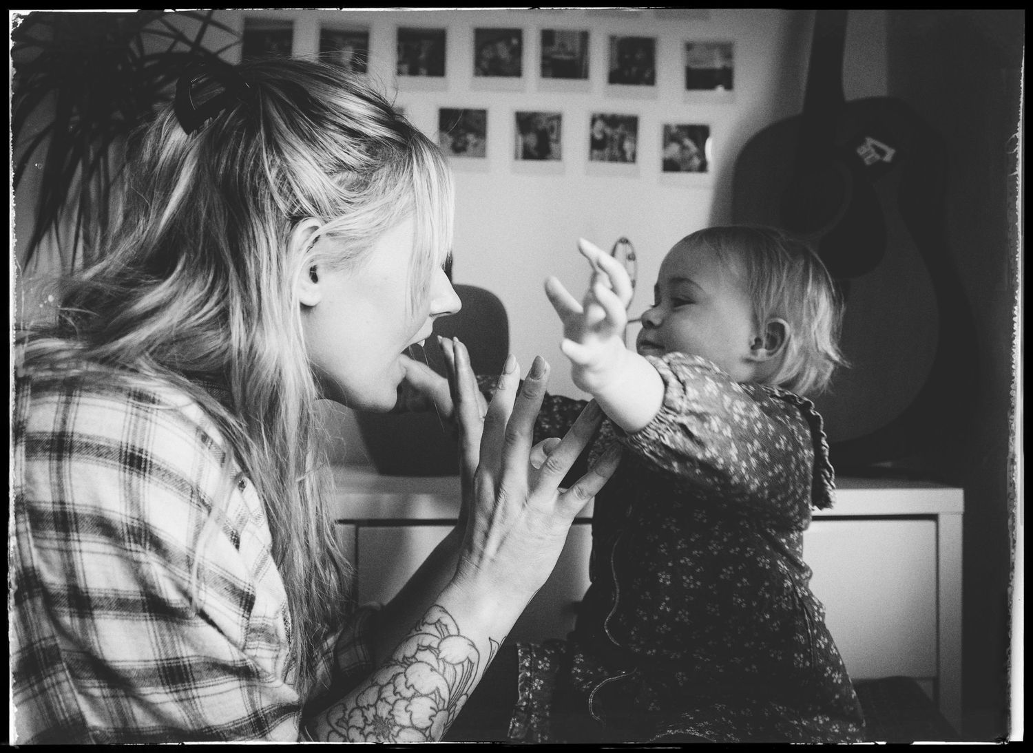 A heartwarming black and white moment captured in a kitchen as two people share playful expressions.