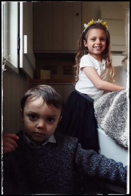 A series of dark moody photographs showing a child peeking from behind a couch cushion.