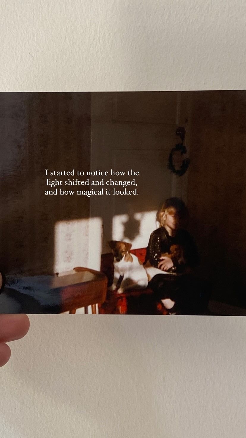 A vintage photograph being held shows a person sitting in a room with overlaid text about noticing magical light.