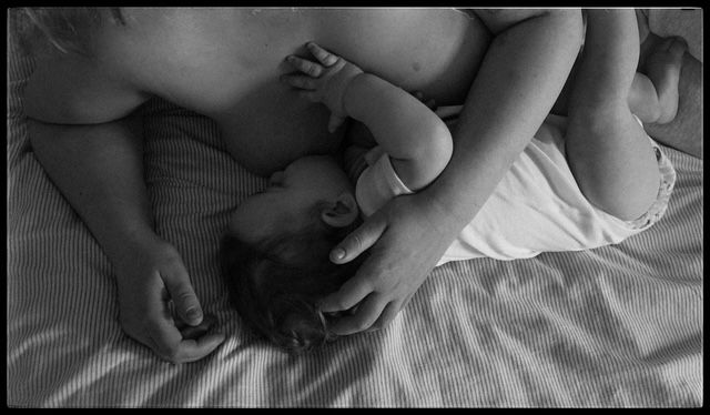 A series of tender moments between a mother and newborn baby lying together on white bedding.