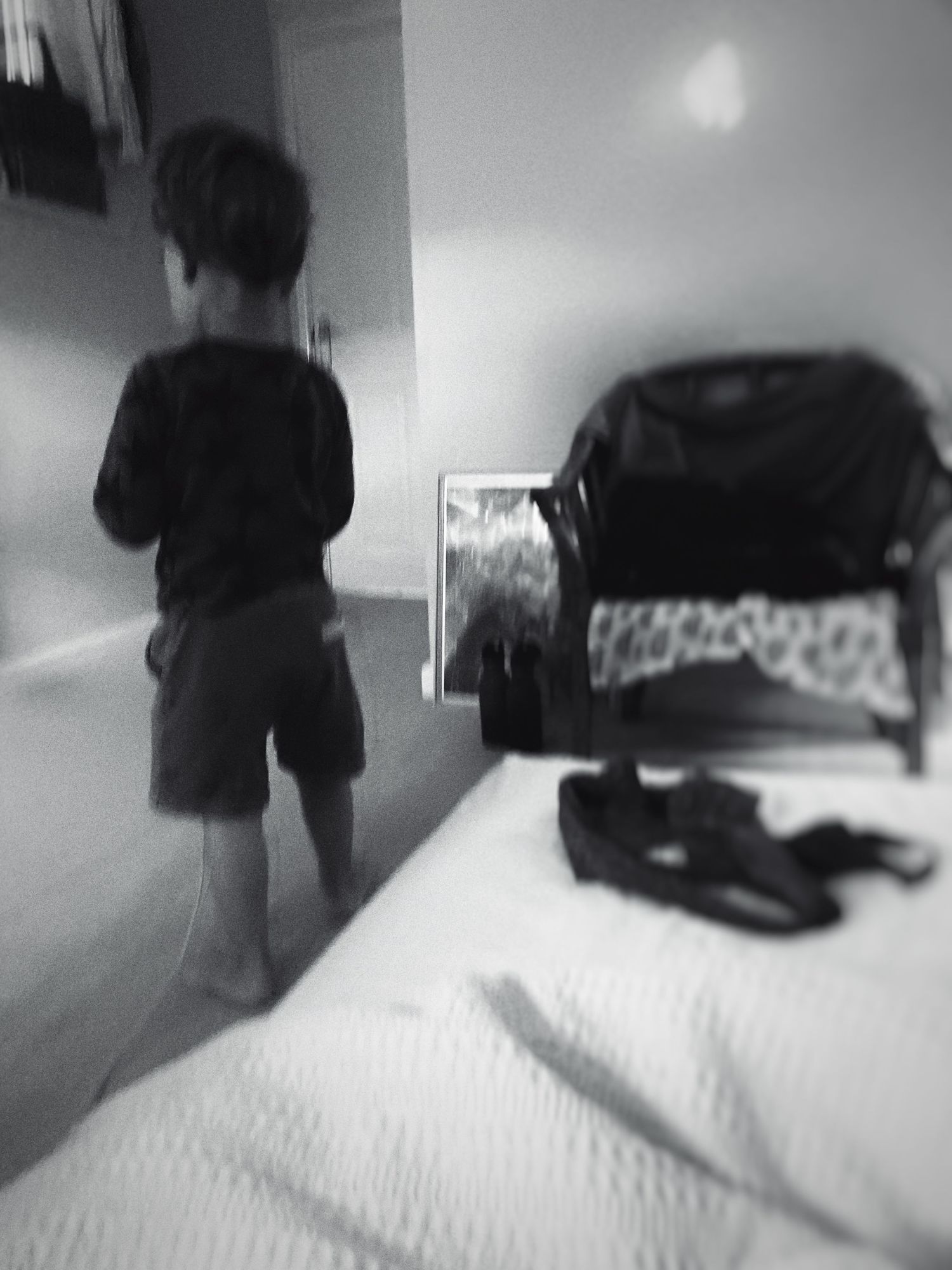 Blurred black and white scene of movement across a bed or furniture.