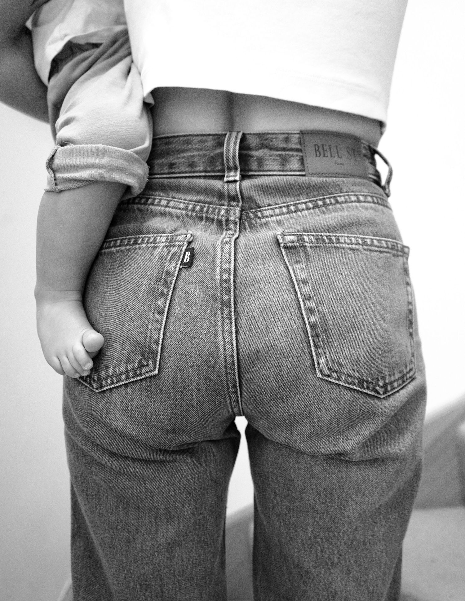 A series of five black and white photos showing different views of classic denim jeans from behind.