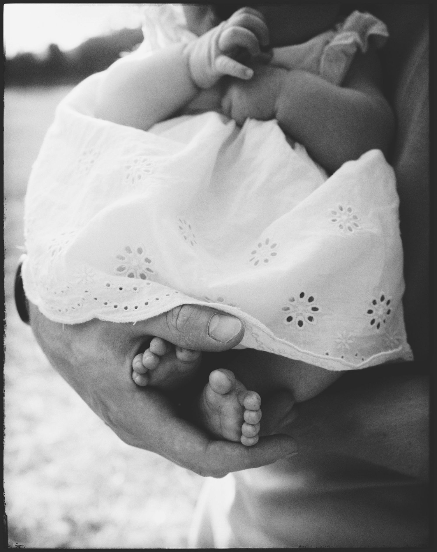 Black and white close-up images showing delicate details of white eyelet lace fabric and hands holding fabric edges.