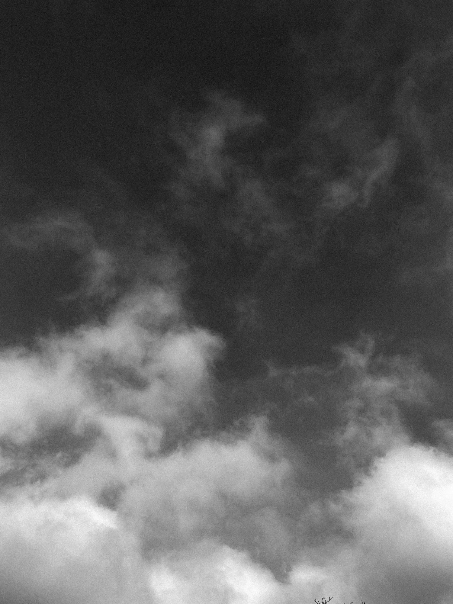 Dramatic black and white cloudscape with swirling clouds against a dark sky.