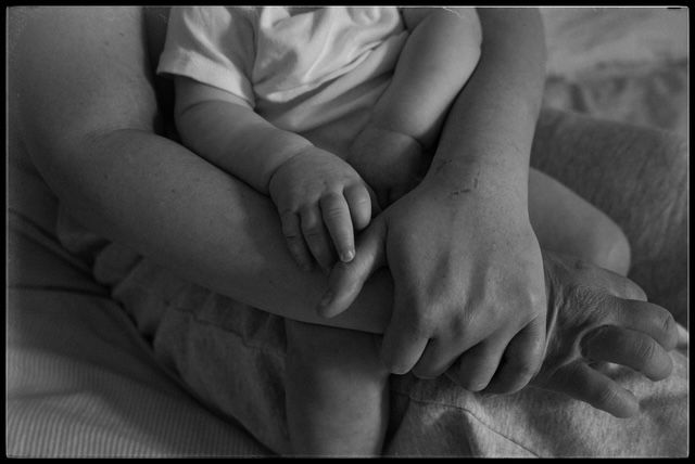 Close-up sequence of gentle infant hand gestures against a soft gray background.