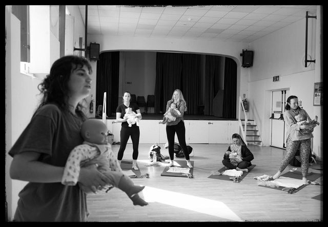A sequence of black and white photos showing people practicing yoga in a studio setting.