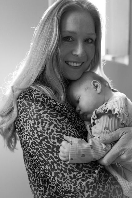 A tender moment between a mother in a leopard print top cradling a sleeping infant shows a sequence of gentle poses.