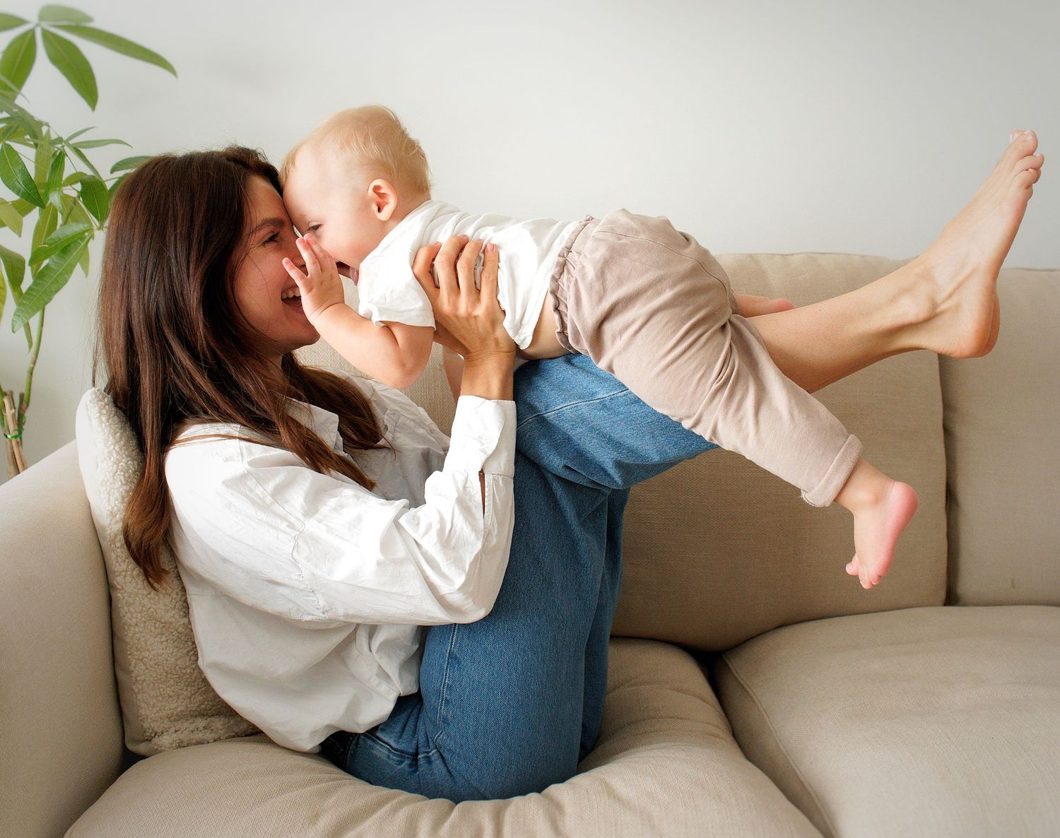 A sequence of playful moments captured on a white couch with natural light and plants in the background.