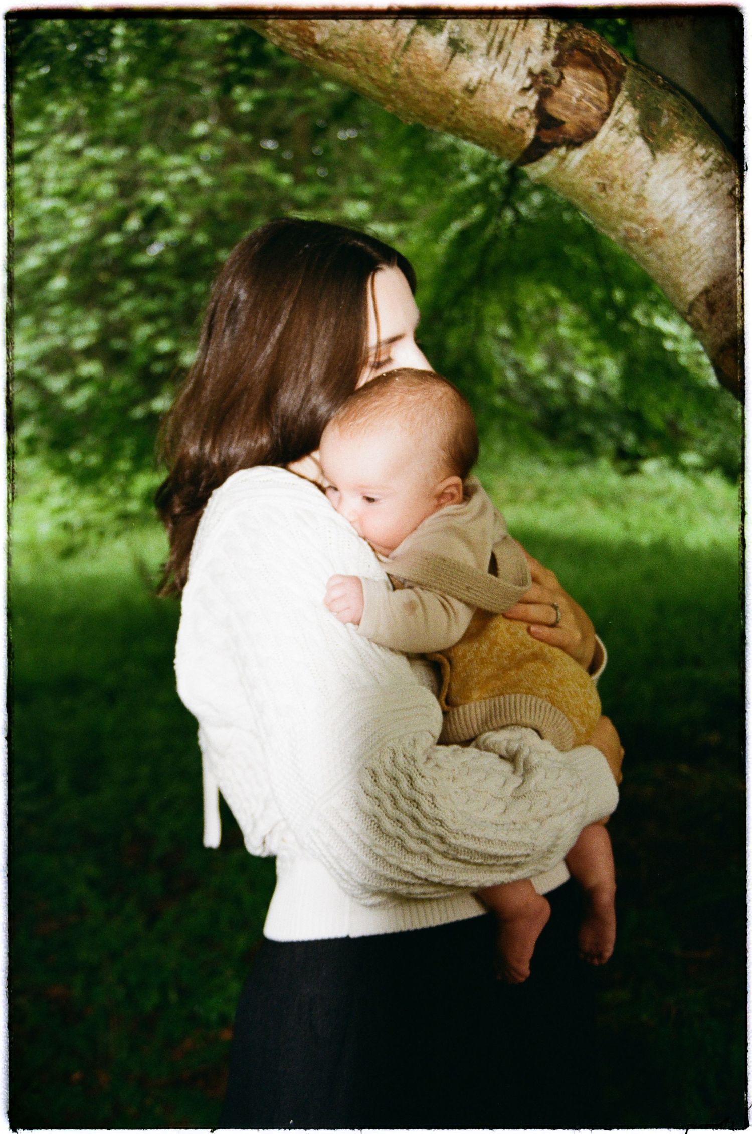 Tender embrace captured against lush green foliage in natural outdoor setting.