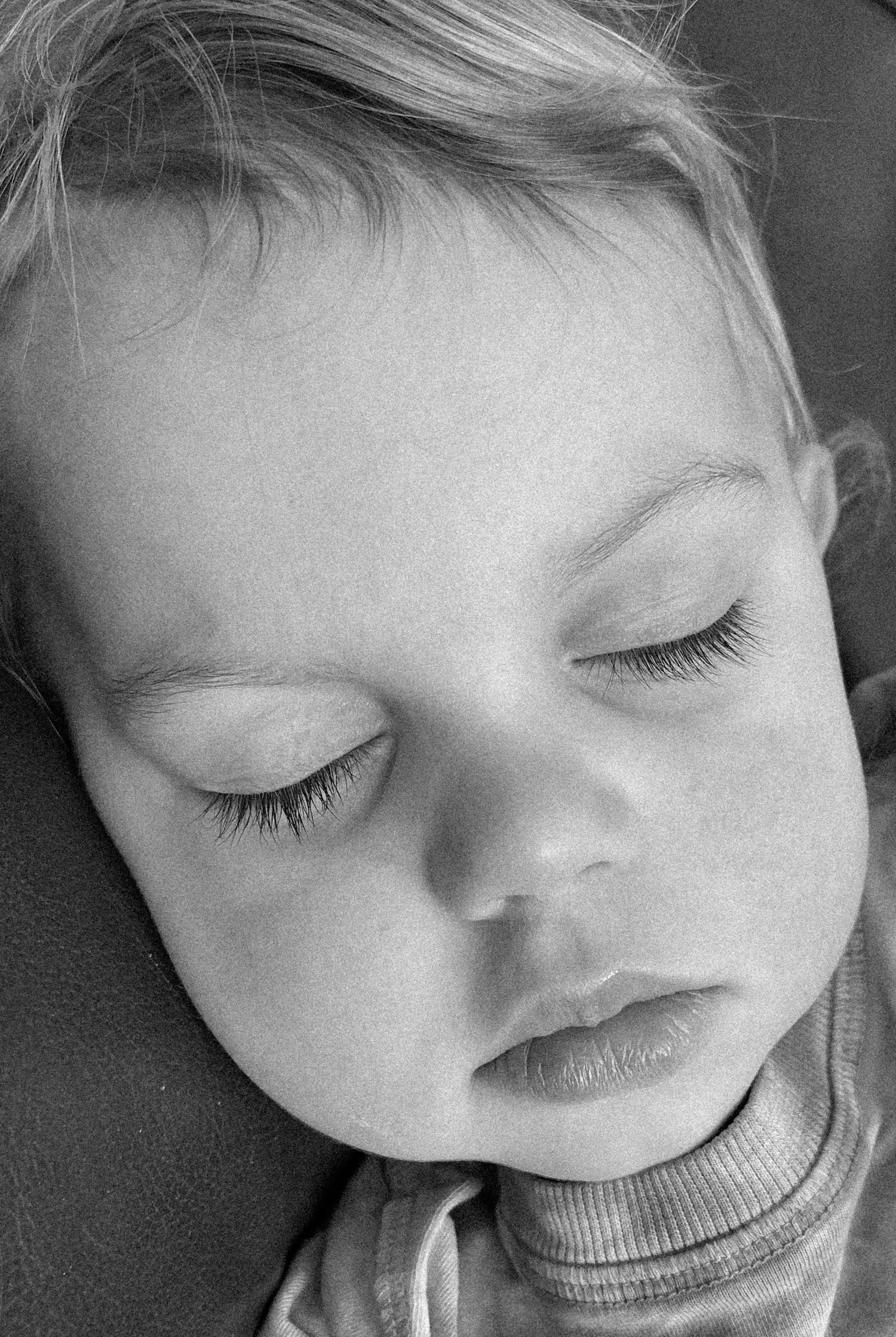 Close-up portrait of a young child's expressions in black and white.