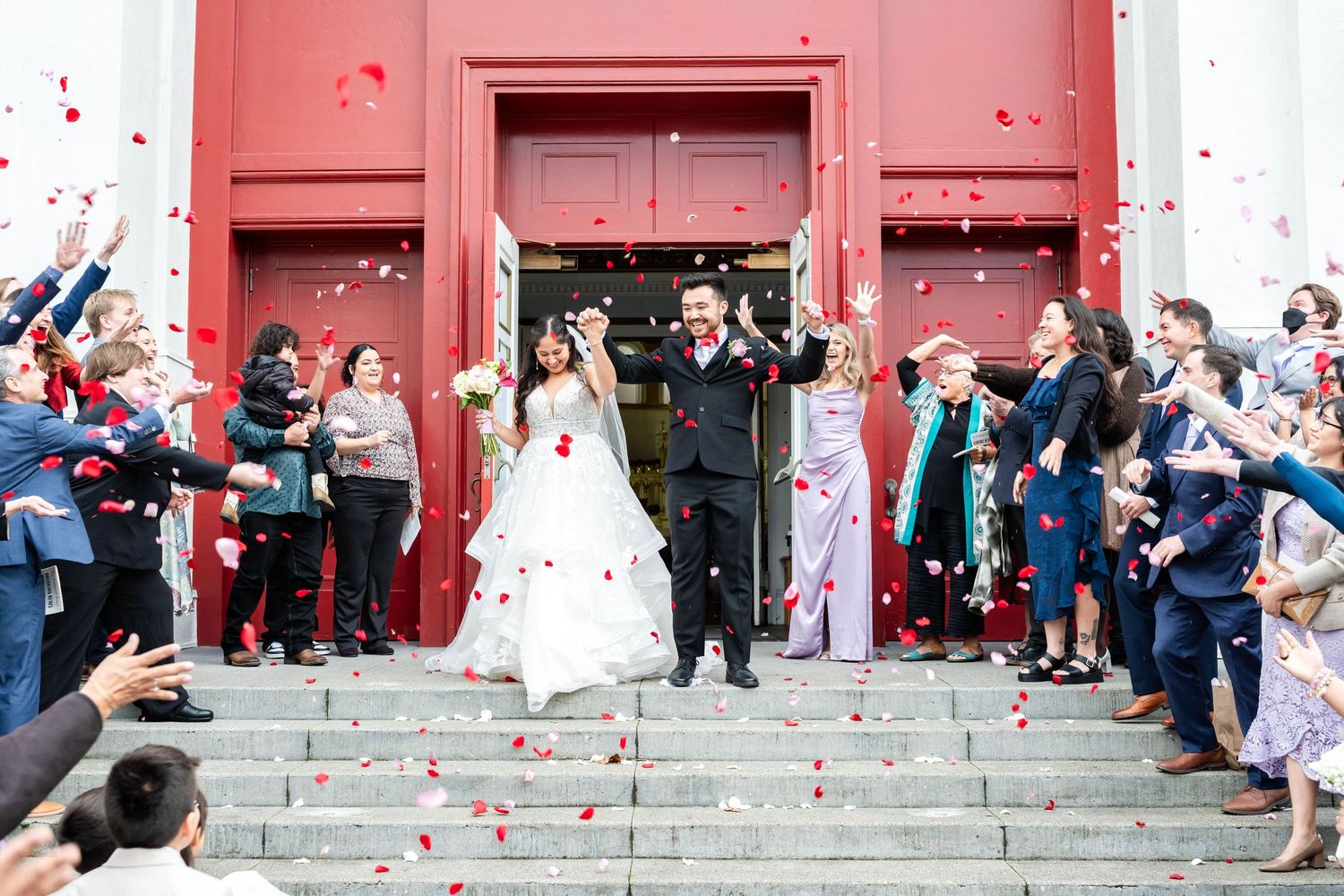 a happy bride and groom leaving a church after getting married. confetti is being thrown in the air around them
