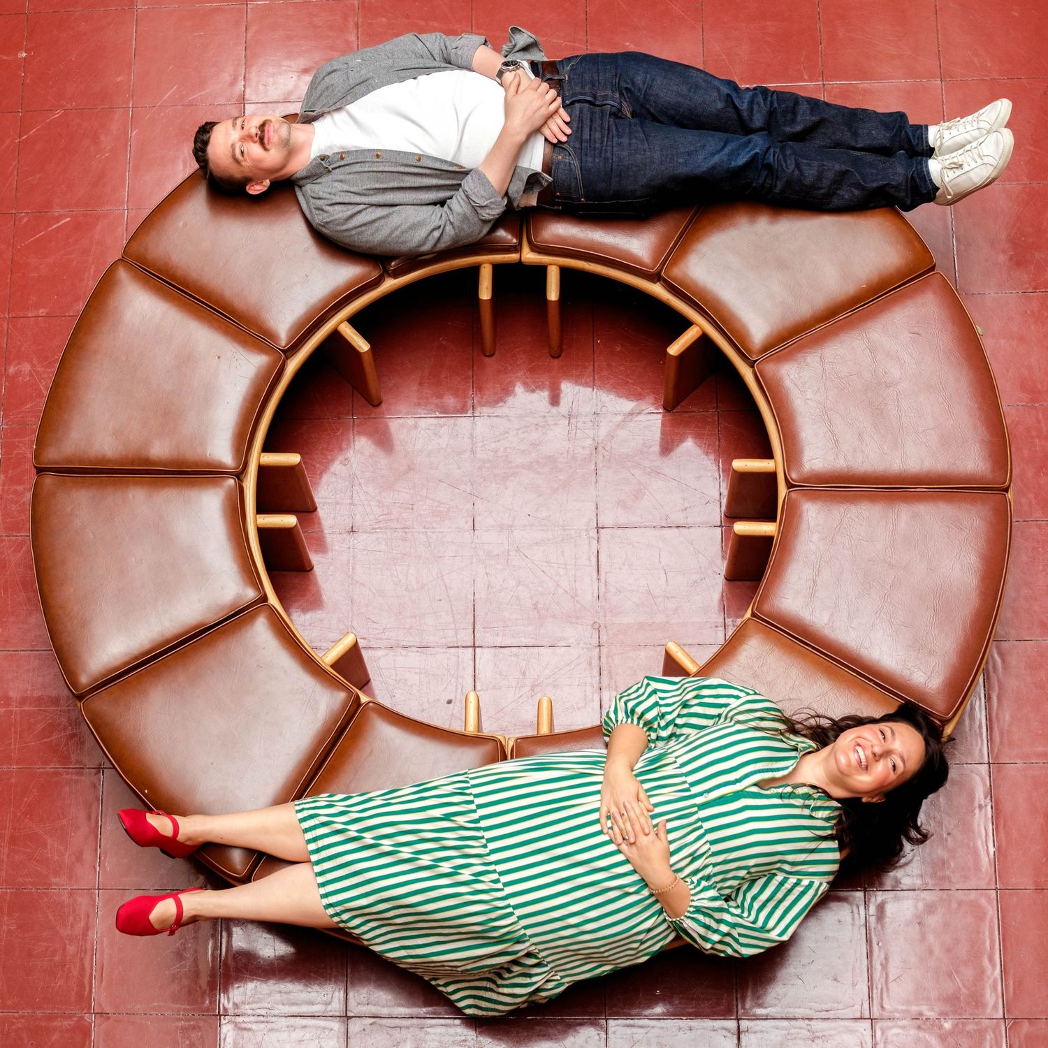 a happy couple recently engaged, laying on a bench at the marin county civic center
