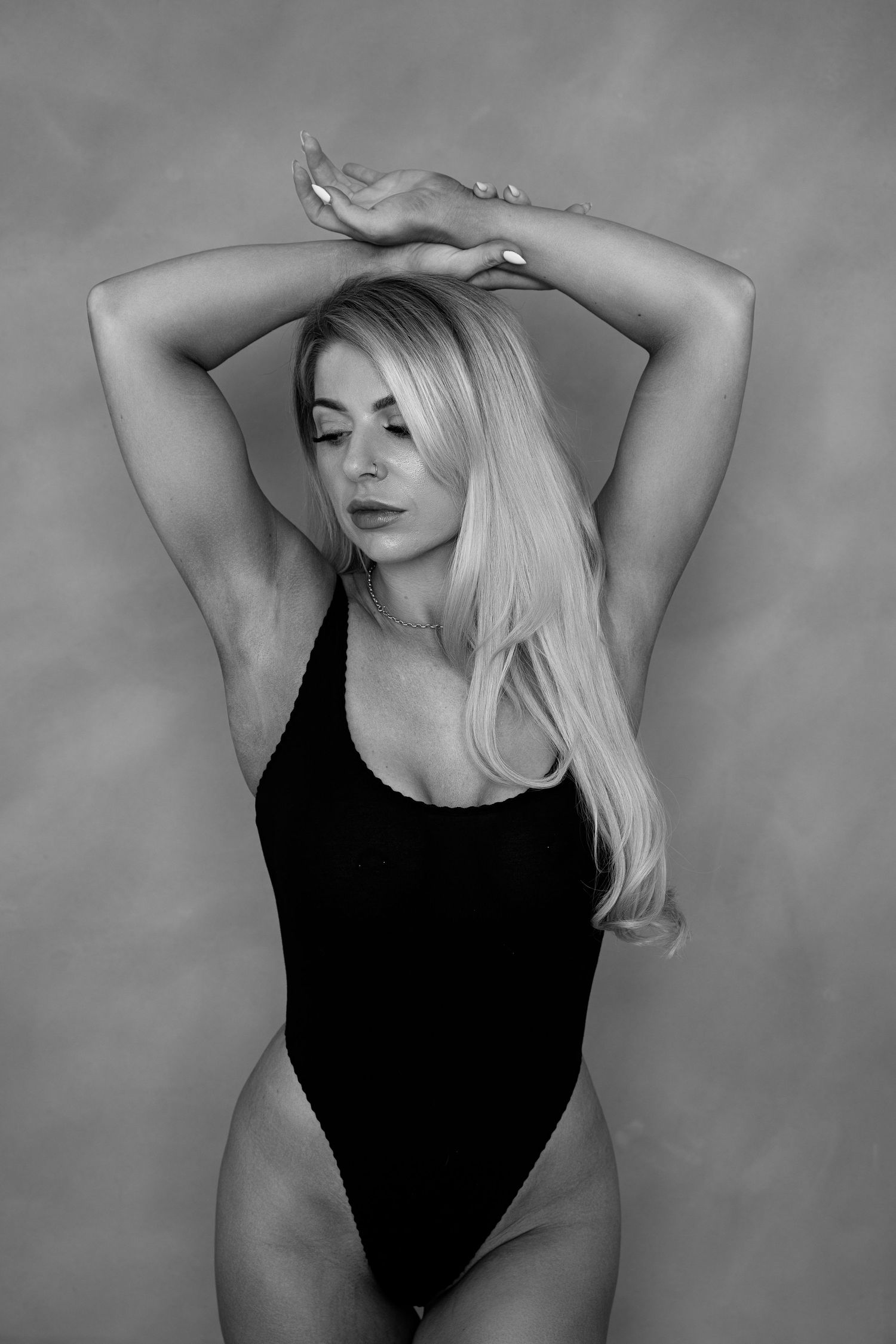 Black and white confidence portrait of woman during empowering boudoir photography session.