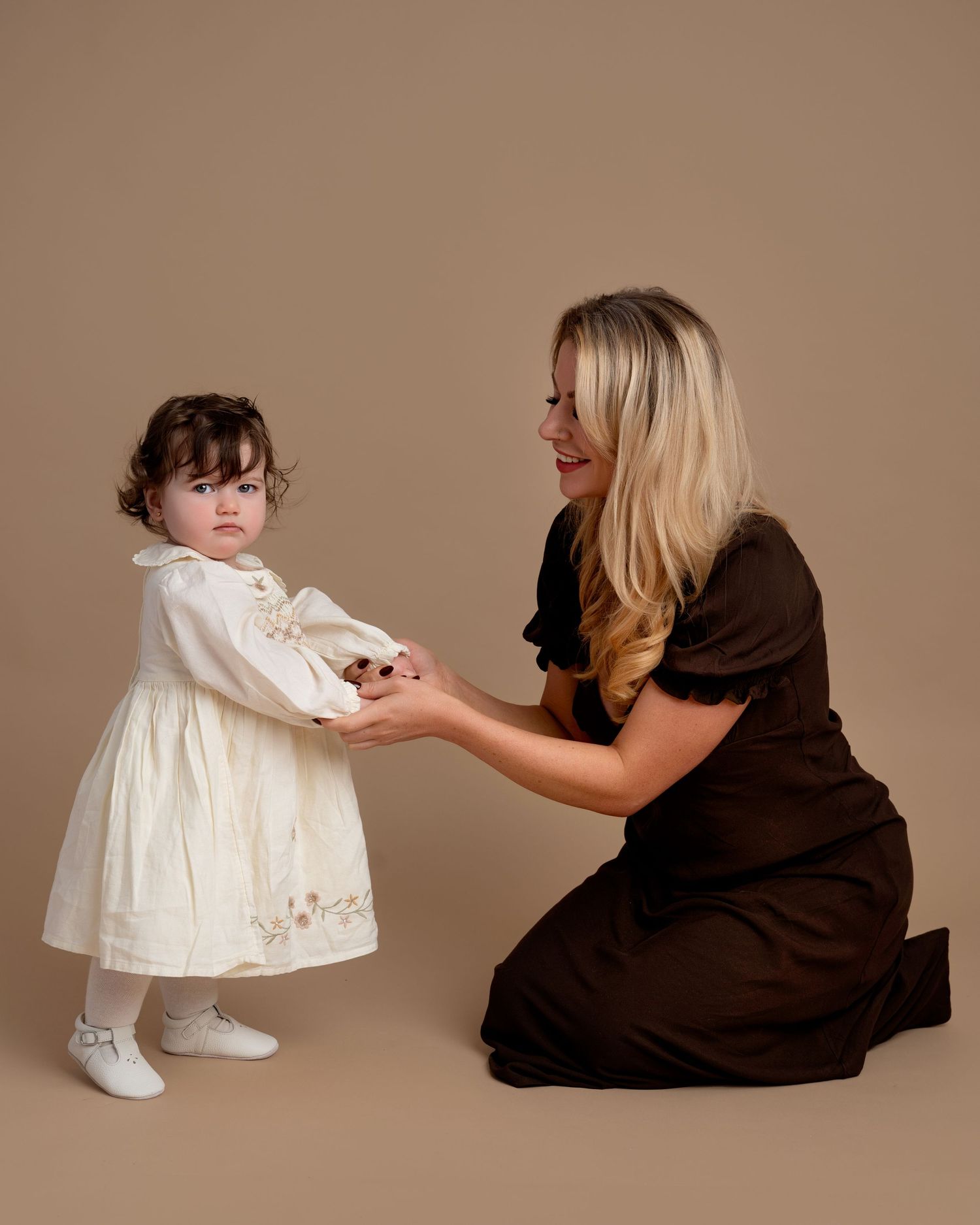 Mother holding toddler daughter during a natural studio family photography session in Lancashire