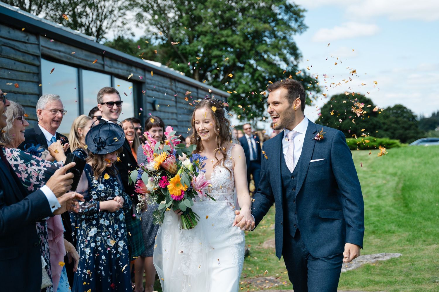 Happy moment of bride and groom walking past guests, surrounded by laughter and celebration