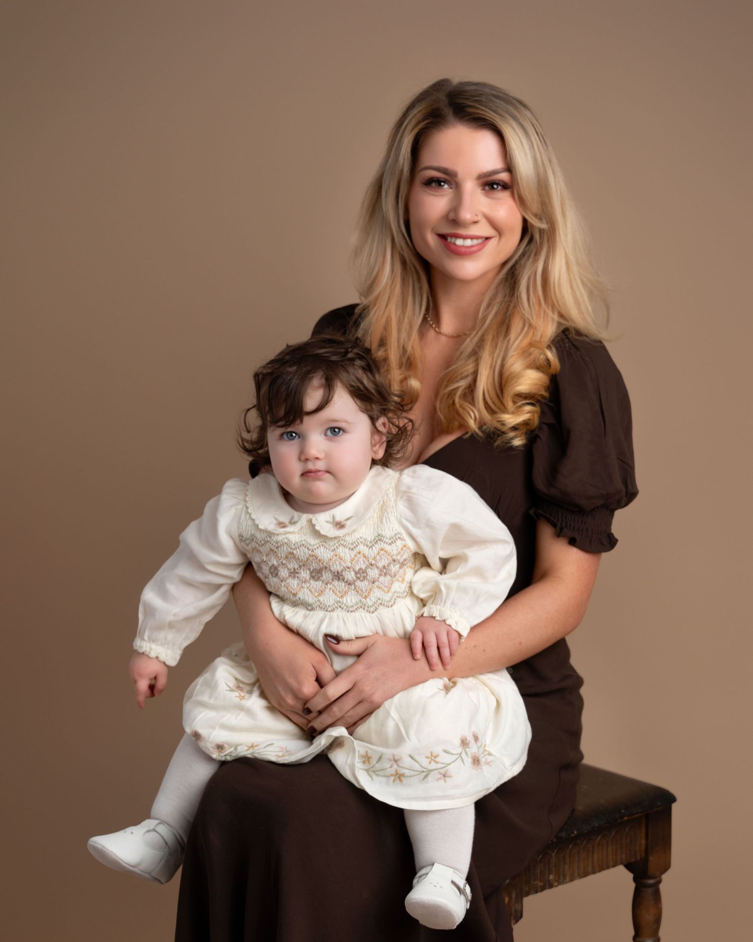 Mother holding toddler daughter during a natural studio family photography session in Lancashire