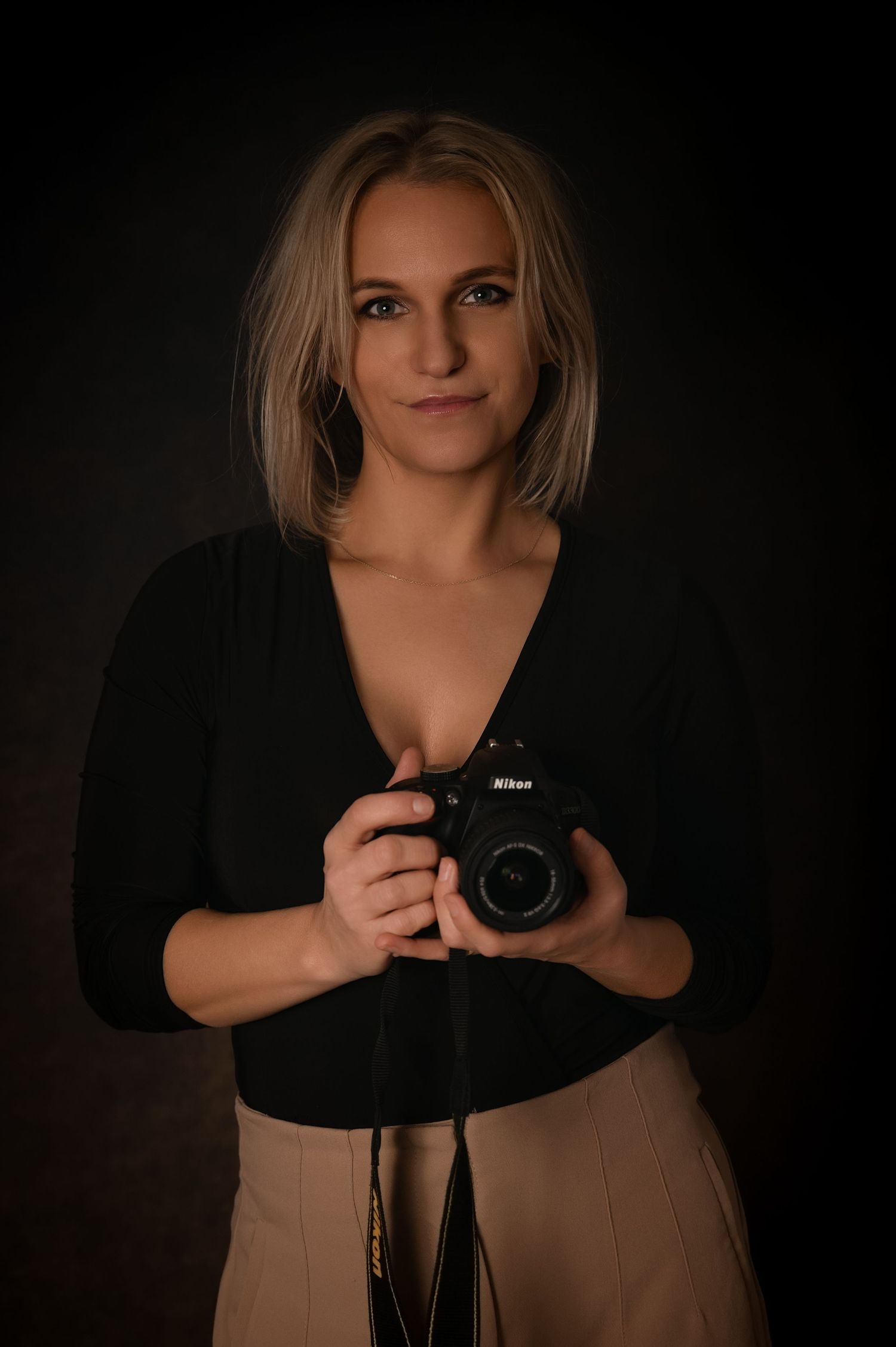 Fine art portrait of a woman in a burnt orange satin dress, posing against a dark background