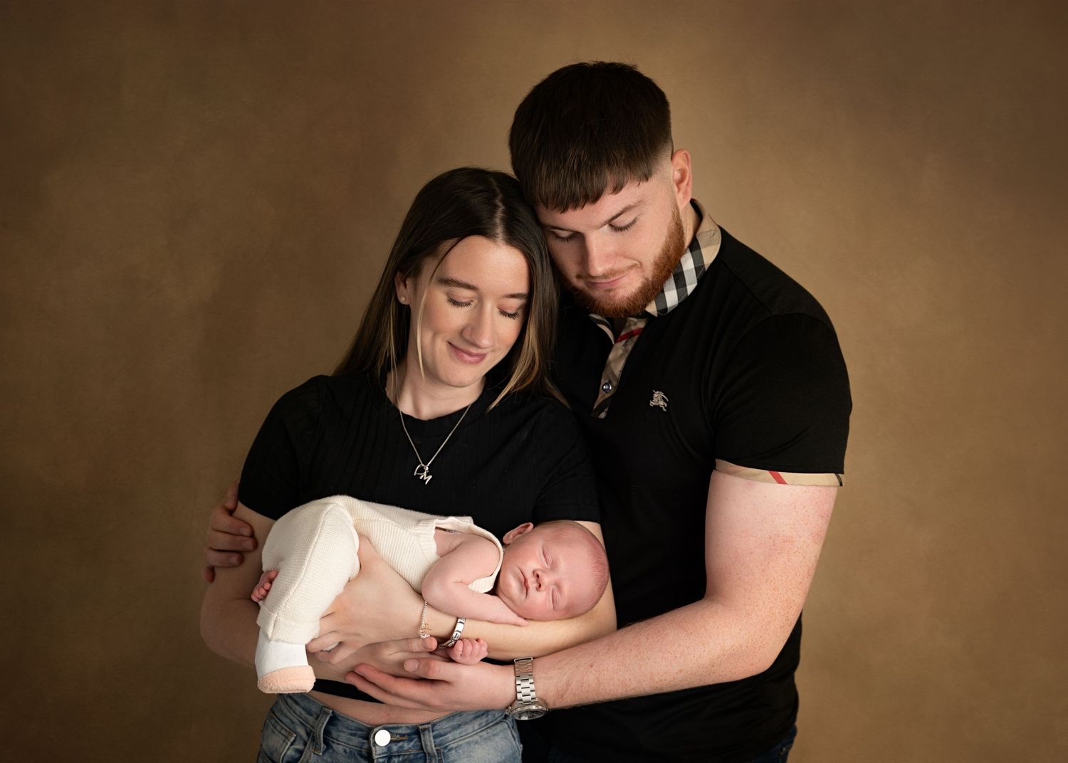 Parents holding their newborn baby together.