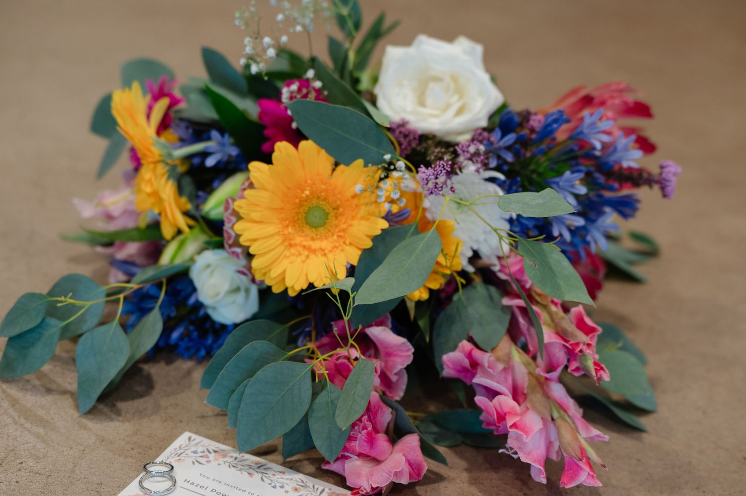 Colourful bridal bouquet with sunflowers, roses, snapdragons and greenery
