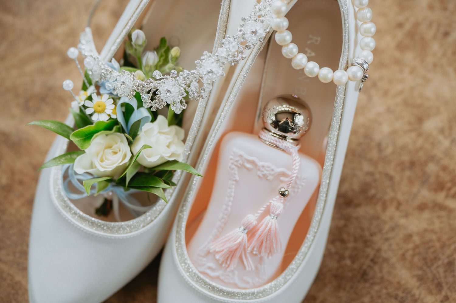Close-up of a white wicker heart decorated with wedding flowers and ribbon, used as romantic wedding ceremony or reception decor.