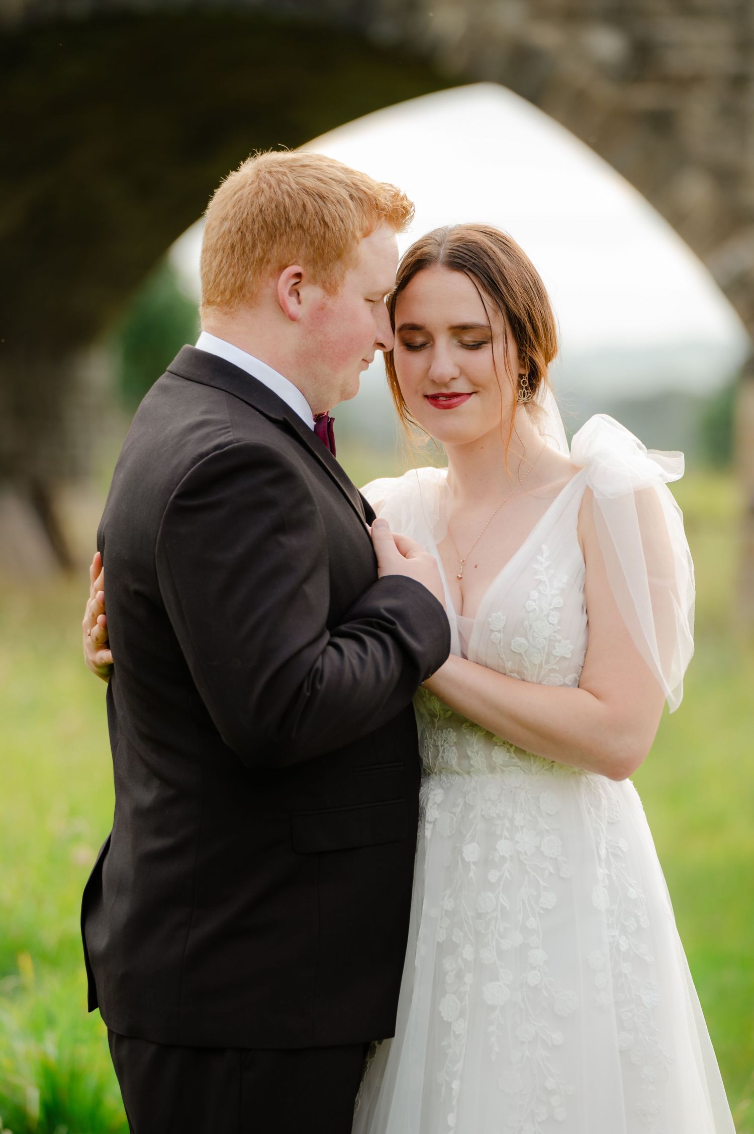Bride and groom sharing a quiet moment, bride’s veil blowing in the breeze