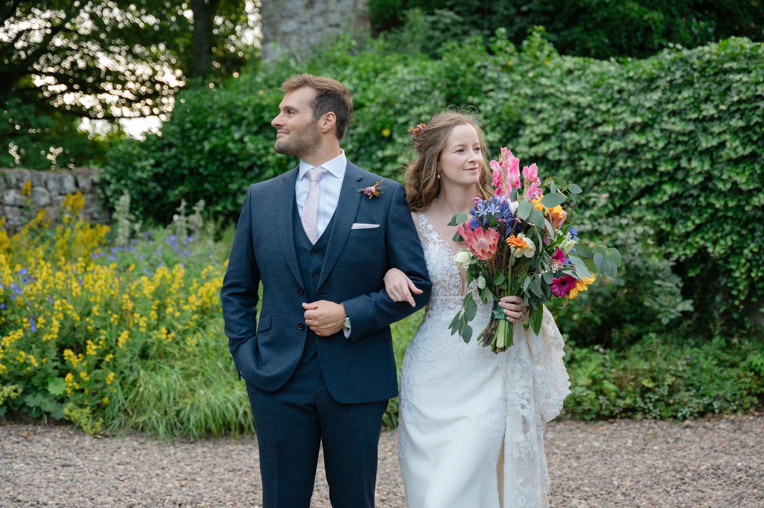 Bride and groom walking together in garden after ceremony
