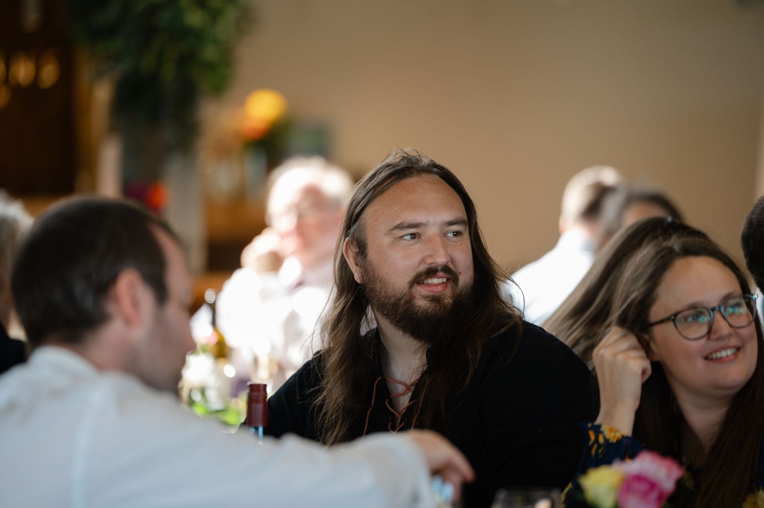Wedding guests chatting and smiling during dinner at the reception