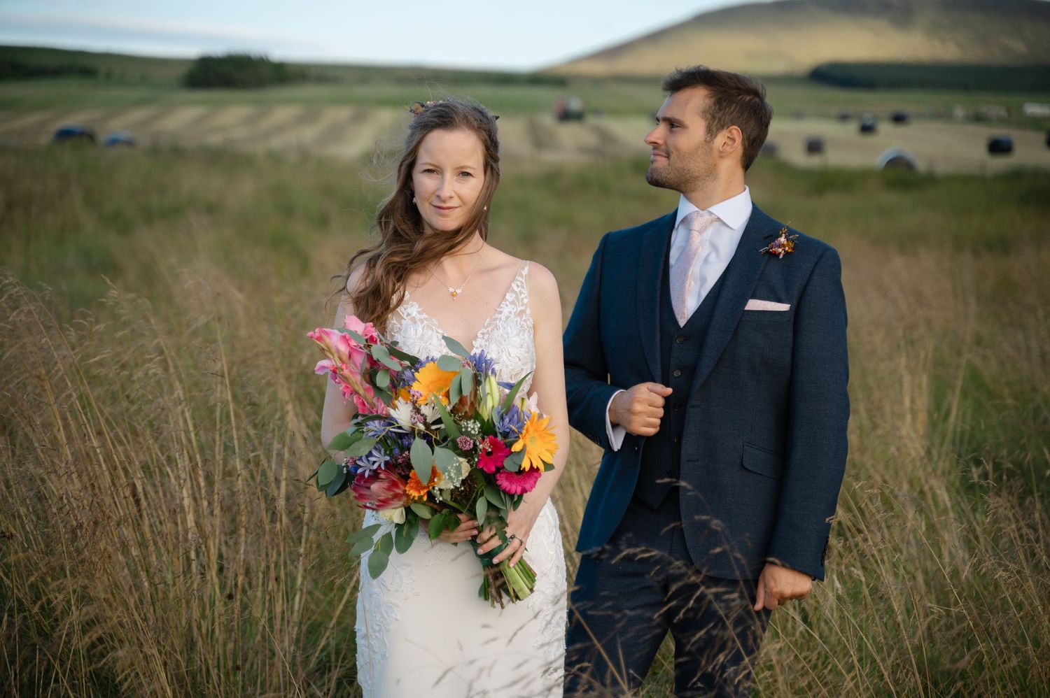 Wedding couple smiling at each other during relaxed outdoor portrait