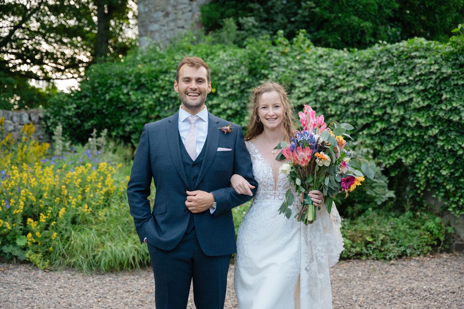 Wedding couple smiling for portrait in lush green garden