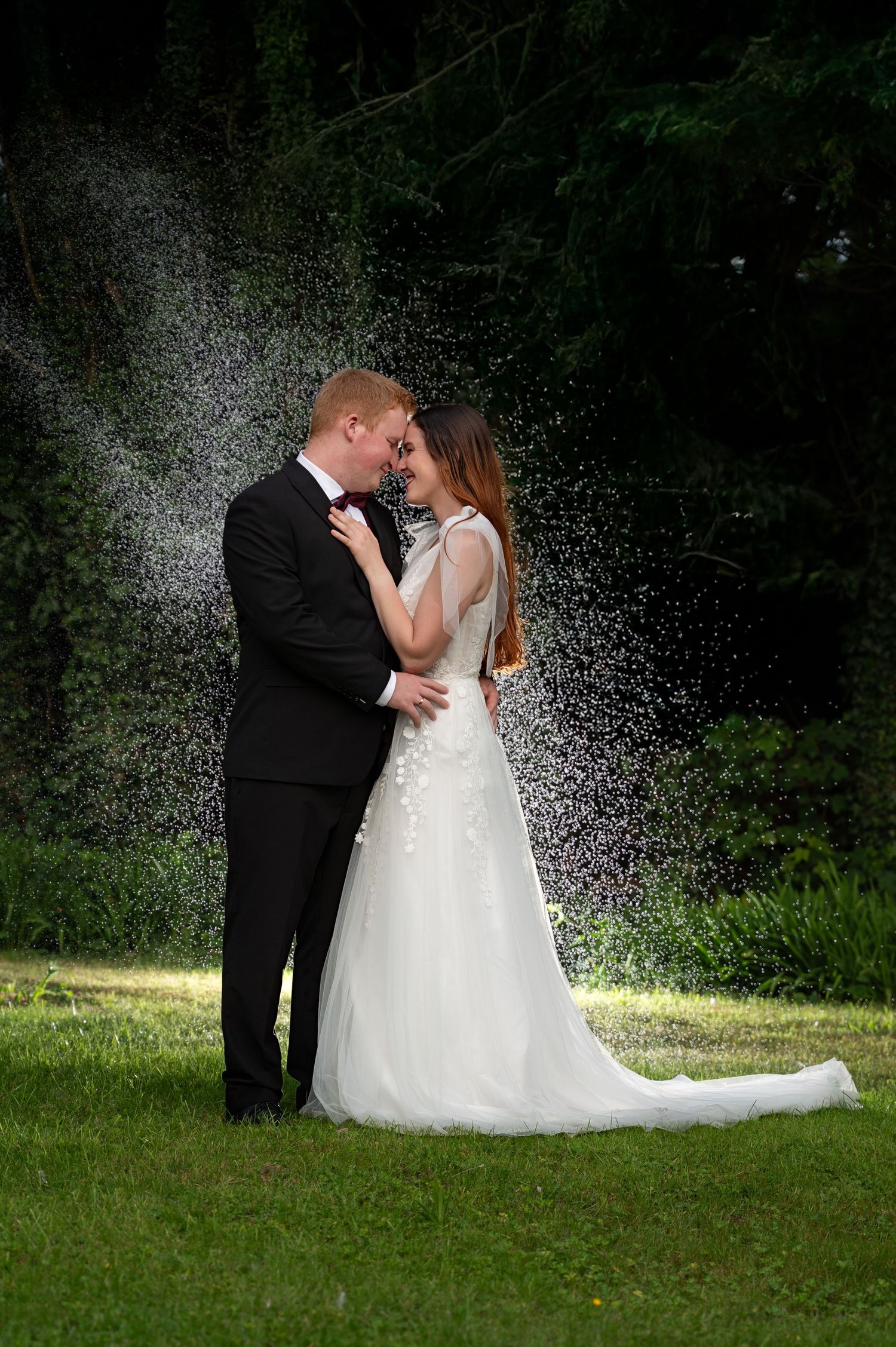 Bride and groom sharing a quiet kiss under soft evening light with mist behind them